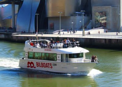 Turistas a bordo del barco Bilboats con el Museo Guggenheim de fondo
